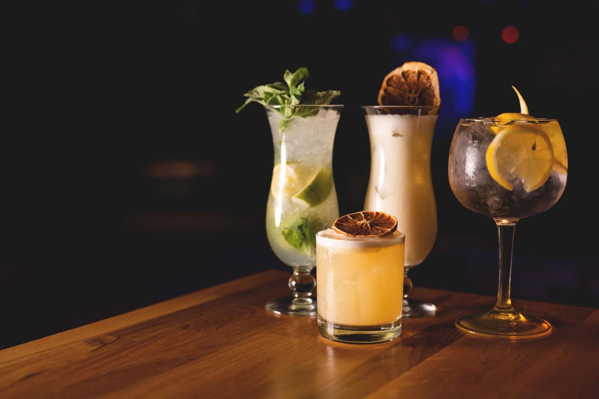 斯维诺乌伊希切丽笙布鲁酒店 外观 照片 The photo showcases a collection of four different cocktails displayed on a wooden table. 

1. **Mojito**: A tall glass filled with lime slices, mint leaves, and a clear liquid, likely rum-based, garnished with fresh mint.
2. **Creamy Cocktail**: A s