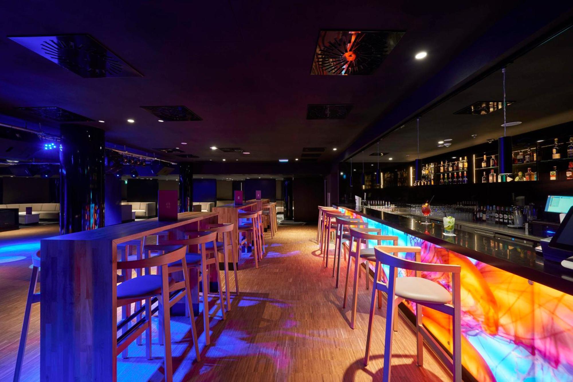 斯维诺乌伊希切丽笙布鲁酒店 外观 照片 The photo depicts a modern bar interior with a sleek and contemporary design. There are high wooden stools positioned along a bar counter, which features vibrant, colorful lighting underneath. The bar area is dimly lit, creating a nightlife ambiance,