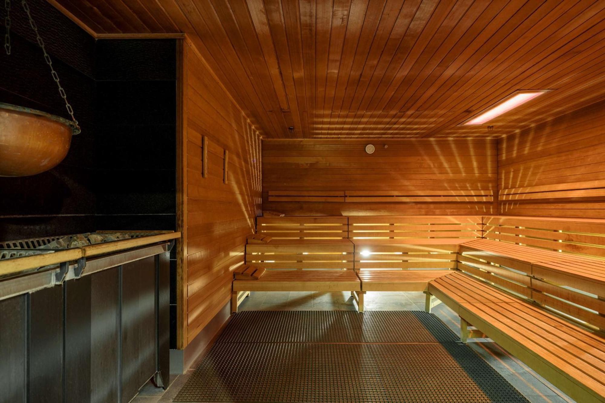 斯维诺乌伊希切丽笙布鲁酒店 外观 照片 The photo shows the interior of a sauna. The walls and benches are made of wood, creating a warm and inviting atmosphere. There is a heater, likely for generating steam, and a metal rack connected to it, perhaps for holding stones or water. The desig