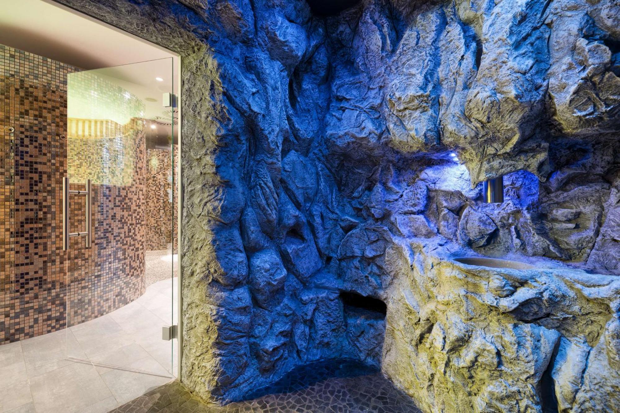 斯维诺乌伊希切丽笙布鲁酒店 外观 照片 The photo shows a spa-like environment with a cave-like design. The walls are styled to resemble natural rock formations, featuring textures and colors that suggest a stone surface. Soft blue lighting highlights the contours of the rocks, creating a 